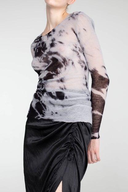 Close-up of Shibori-dyed wool jumper, showing intricate black patterns on soft fabric