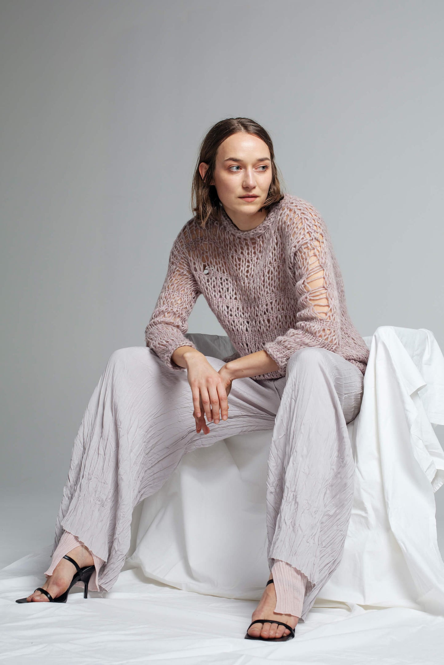 Model wearing an open-knit alpaca pullover with silk pants.